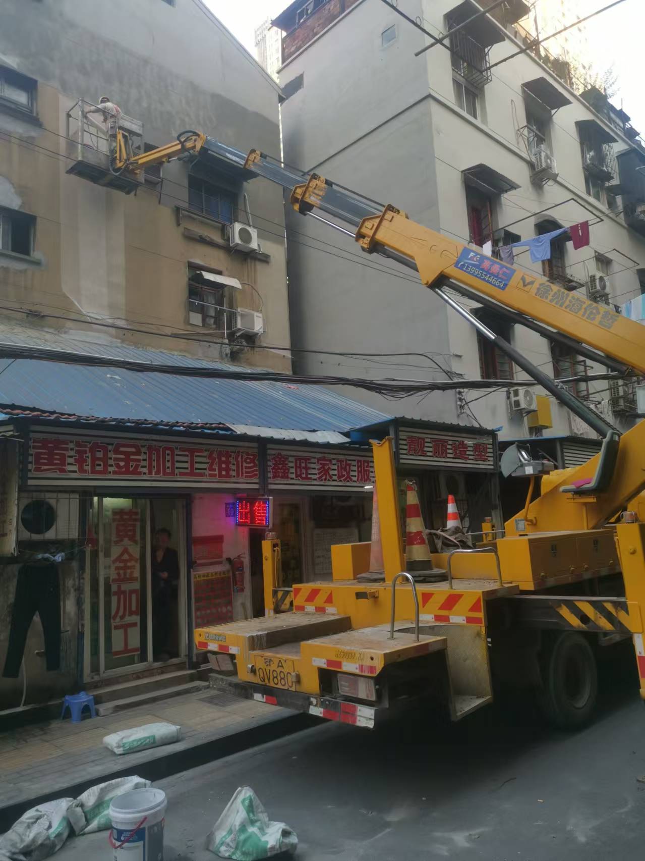 22米登高車載人粉刷外墻施工現(xiàn)場